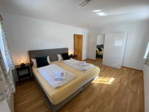 a bedroom with a large bed with towels on it at Traumferienwohnungen Schliersee in Schliersee