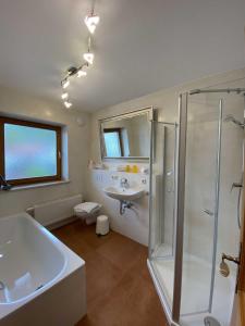a bathroom with a tub and a sink and a shower at Traumferienwohnungen Schliersee in Schliersee