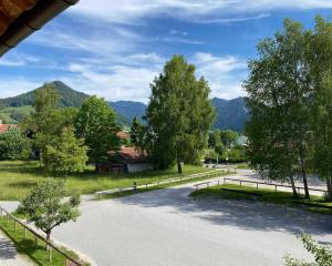 a winding road with trees and mountains in the background at Traumferienwohnungen Schliersee in Schliersee