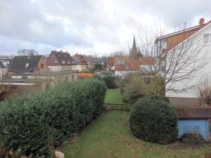 a view of a yard with bushes and houses at Ferienwohnung Paula in Buxtehude +24 photos