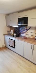 a kitchen with white cabinets and a stove top oven at Ferienwohnung Paula in Buxtehude