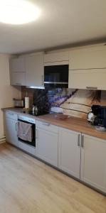 a kitchen with white cabinets and a wooden counter top at Ferienwohnung Paula in Buxtehude