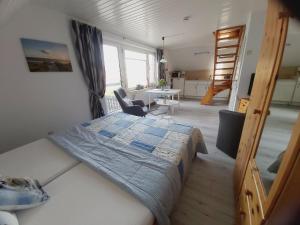 a bedroom with a bed and a table in a room at Apartment Storchennest in Bensersiel +6 photos