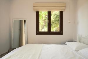 a bedroom with a white bed and a window at The Light House Chorefto in Chorefto