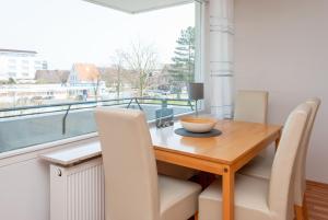 Un comedor con mesa y sillas y una ventana. en Haus Hanseatic, Wohnung 211, en Duhnen