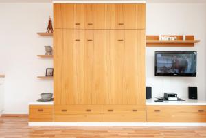 un gran armario de madera con TV en la pared en Haus Hanseatic, Wohnung 211, en Duhnen
