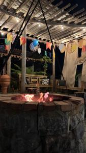a patio with a fire pit with clothes hanging up at Casa Pedra da Canastra in São José do Barreiro