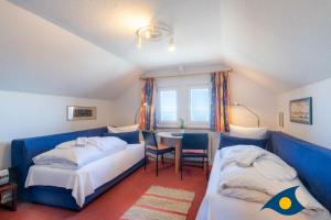 a bedroom with two beds and a table in it at Strandvilla DG in Bansin