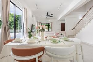 a white dining room with a table and chairs at Rawang Landed Homestay - 2Sty Corner House in Rawang