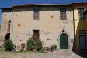 an old house with a green door and windows at Il casale dei tigli in Limite +8 photos