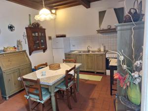 a kitchen with a table and chairs and a sink at Il casale dei tigli in Limite