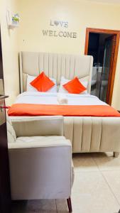 a large bed with orange pillows in a room at Rosette Haven 2 in Nairobi
