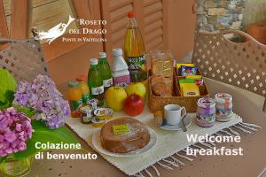 San BernardoにあるLa Rosa al Roseto del Dragoの食べ物と飲み物が置かれたテーブルと食べ物が置かれたテーブル