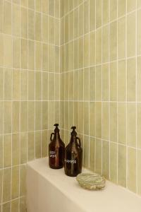 two bottles of soap sitting on a shelf in a bathroom at The Light House Chorefto in Chorefto