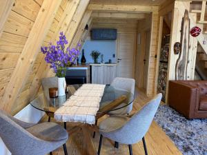 a dining room with a glass table and chairs at Hygge villa in Žabljak