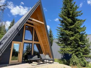 a small cabin with a large window and a tree at Hygge villa in Žabljak