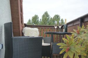een patio met 2 tafels en stoelen op een balkon bij FischLANDinSicht in Ribnitz-Damgarten