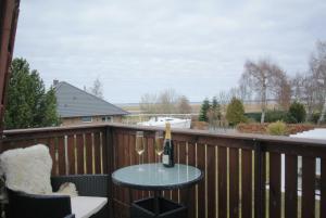 een tafel met een fles wijn op een balkon bij FischLANDinSicht in Ribnitz-Damgarten