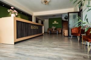 vestíbulo de un hotel con sillas y recepción en Green Garden Resort, en Odobeşti