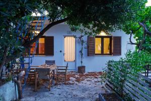 a house with a table and chairs under a tree at The Light House Chorefto in Chorefto