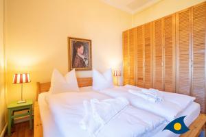Dos camas en una habitación con sábanas y almohadas blancas. en Strandvilla Whg 02, en Bansin 1 foto más