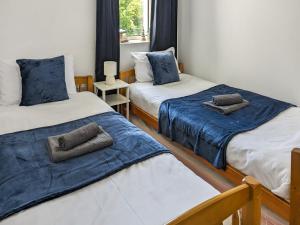 Zimmer mit 2 Betten mit blauer und weißer Bettwäsche in der Unterkunft Miriam's in Croyde