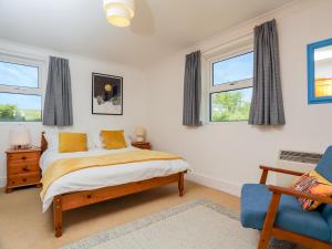 ein Schlafzimmer mit einem Bett und zwei Fenstern in der Unterkunft Miriam's in Croyde