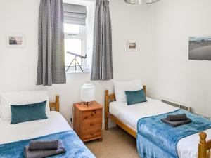 ein Schlafzimmer mit zwei Einzelbetten und einem Fenster in der Unterkunft Miriam's in Croyde + 10 Fotos