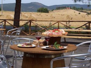 ein Tisch mit zwei Tellern mit Speisen und Weingläsern in der Unterkunft Il Bracconiere in Fonteblanda