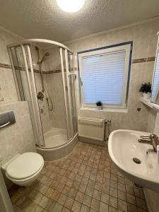 a bathroom with a shower and a toilet and a sink at Ostseebad Göhren 4-Personen-Ferienhaus mit beh WPool in Göhren +13 photos