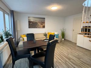 a dining room and living room with a table and chairs at Ostseebad Göhren 4-Personen-Ferienhaus mit beh WPool in Göhren
