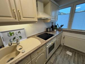 a kitchen with white cabinets and a sink at Ostseebad Göhren 4-Personen-Ferienhaus mit beh WPool in Göhren