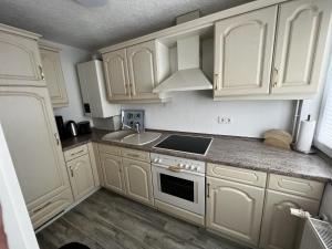 a kitchen with white cabinets and a sink at Ostseebad Göhren 4-Personen-Ferienhaus mit beh WPool in Göhren