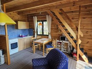 a kitchen and dining room of a log cabin at FH am Haff B in Altwarp +6 photos