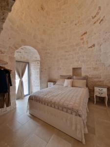 a bedroom with a large bed in a stone wall at Brunaldi Trulli Pool Villa in Martina Franca +47 photos