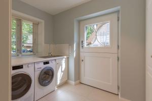 a laundry room with a washing machine and a window at Landhaus unter den Linden in Nieblum
