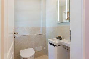 a bathroom with a white toilet and a sink at Landhaus unter den Linden in Nieblum +39 photos