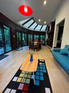 a living room with a table and a couch at Top River Nest- Upper Floor 