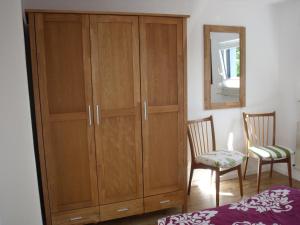 a wooden cabinet in a room with a bed and a mirror at Ferienwohnung Knusperhaus in Xanten