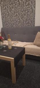 a bottle of wine on a table next to a bed at Apartament city center 118 in Piekary Śląskie