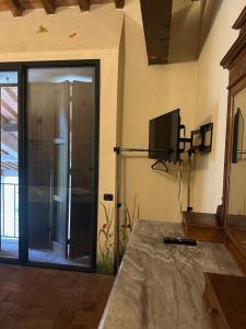 a living room with a tv and a sliding glass door at Niviano Castello in Larzano