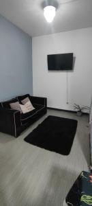 ein Wohnzimmer mit Couch und Flachbildfernseher in der Unterkunft Departamento para dos personas in Río Gallegos