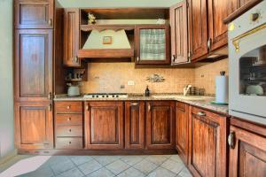 a kitchen with wooden cabinets and a sink at Fronte ciclabile con posto per auto e biciclette in Imperia