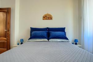 a bed with blue pillows in a bedroom at Fronte ciclabile con posto per auto e biciclette in Imperia