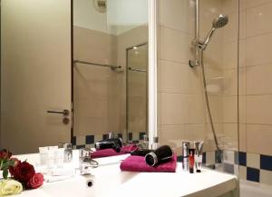 Un baño con lavabo con espejo y ducha. en Park & Relax - Paris Expo Versailles, en Issy-les-Moulineaux 15 fotos más