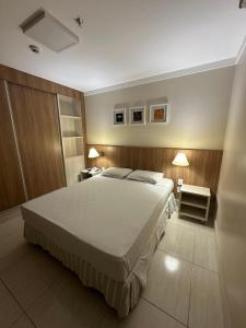 a bedroom with a large bed and two lamps at Piazza diRoma com acesso ao Acqua Park e Splash - Gabriel in Caldas Novas