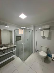 a bathroom with a glass shower and a toilet at Piazza diRoma com acesso ao Acqua Park e Splash - Gabriel in Caldas Novas