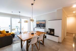 Un comedor y una sala de estar con mesa y sillas. en Quartier 7 App 03, en Ahlbeck
