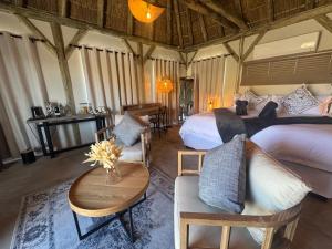 a bedroom with two beds and a table and chairs at Tsauchab River Camp in Sesriem +99 photos