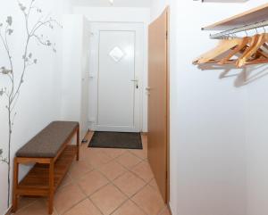 a corridor with a door and a bench in a room at Ferienhaus Satelsrönne 23 - Wattlaeufer in Duhnen +9 photos